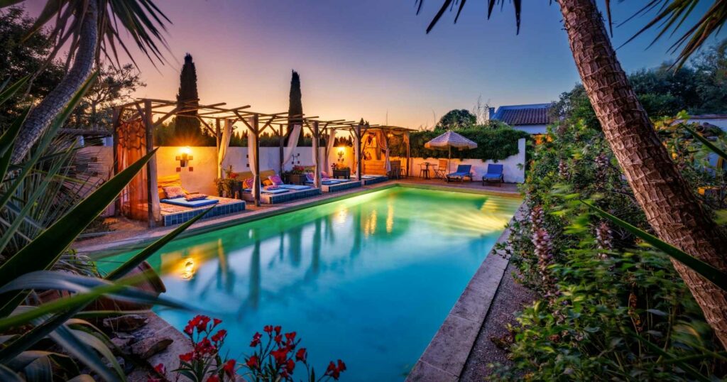 Piscine éclairée au crépuscule d’un domaine équestre à Vestric-et-Candiac